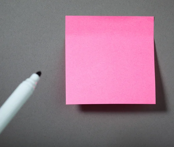 Roze kleverige papieren op de grijs muur — Stockfoto