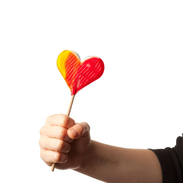 Hand som håller godis hjärtat isolerad på vit — Stockfoto