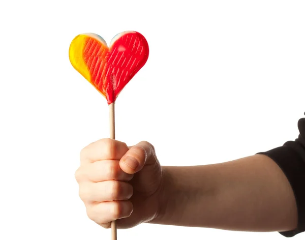 Hand som håller lollipop hjärtat isolerad på vit — Stockfoto