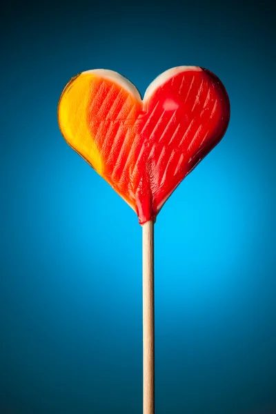 Lollipop hjärtat på blå bakgrund — Stockfoto