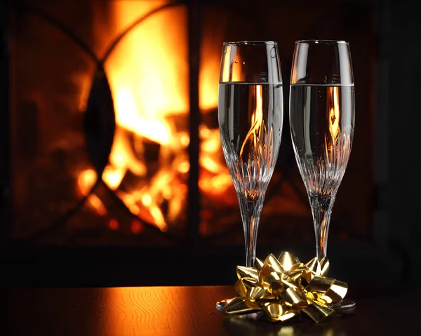 Ποτήρια με σαμπάνια με χριστουγεννιάτικη συνοδεία, φωτιά ως φόντο — Φωτογραφία Αρχείου