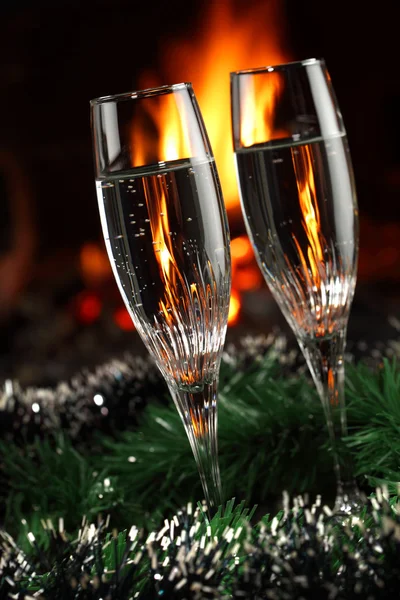 Ποτήρια με σαμπάνια με χριστουγεννιάτικη συνοδεία, φωτιά ως φόντο — Φωτογραφία Αρχείου