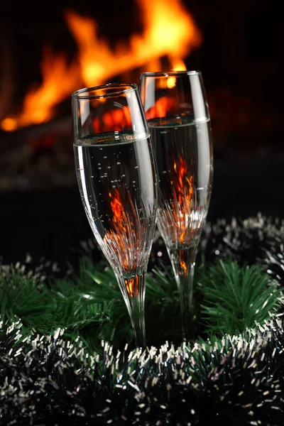 Copas con champán con séquito de Navidad, fuego como fondo — Foto de Stock