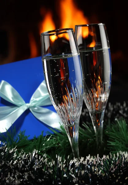 Copos com champanhe com comitiva de Natal, fogo como fundo — Fotografia de Stock