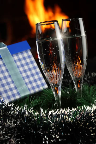 Kieliszki z szampanem w świątecznym towarzystwie, ogień jako tło — Zdjęcie stockowe