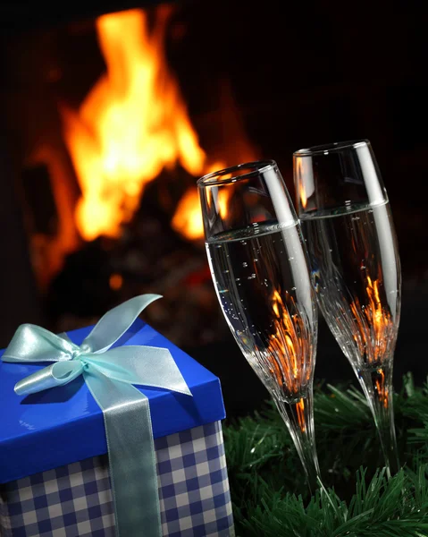 Bicchieri con champagne con entourage natalizio, fuoco come sfondo — Foto Stock
