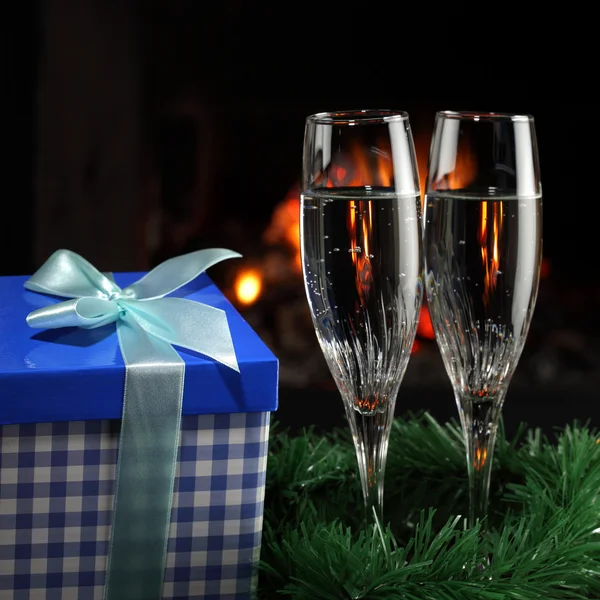 Kieliszki z szampanem w świątecznym towarzystwie, ogień jako tło — Zdjęcie stockowe