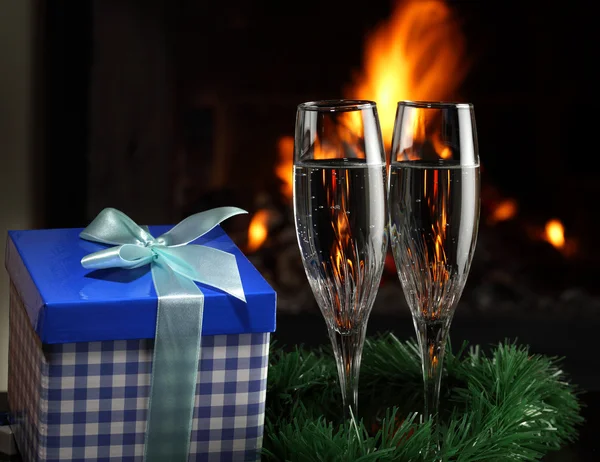 Бокалы с шампанским с рождественским антуражем, огонь на заднем плане — стоковое фото