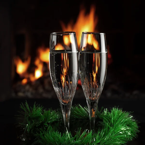 Verres avec champagne avec entourage de Noël, le feu comme arrière-plan — Photo
