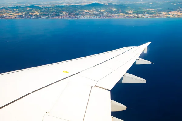 Wing of airplane with view to the sea — Stock Photo, Image