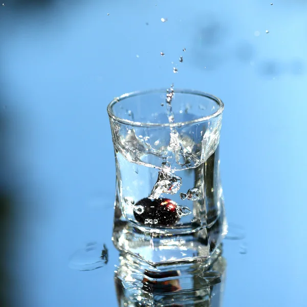 Vodka splash på blå — Stockfoto