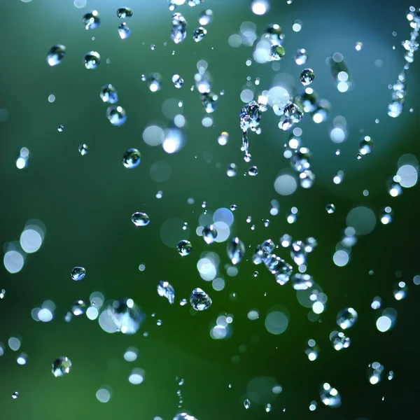 Deeltjes van water op groen — Stockfoto