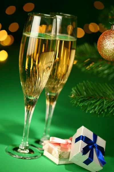 Festive champagne glasses with gifts — Stock Photo, Image
