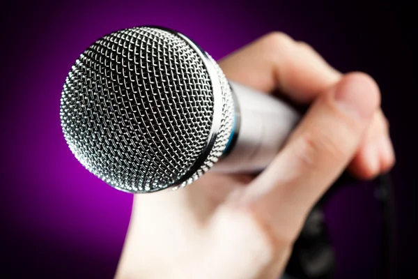 Mão segurando o microfone — Fotografia de Stock