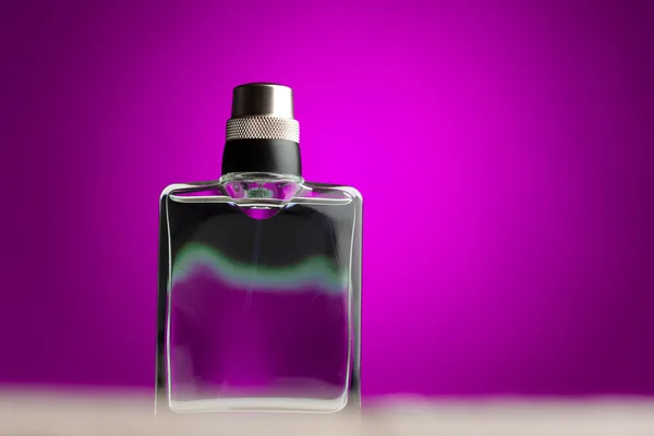 Fles met parfum op paarse achtergrond — Stockfoto