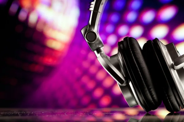 Headphones against purple disco background — Stock Photo, Image
