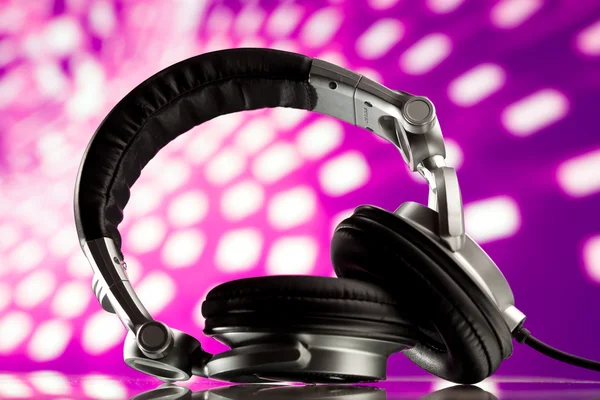 Headphones against purple disco background — Stock Photo, Image