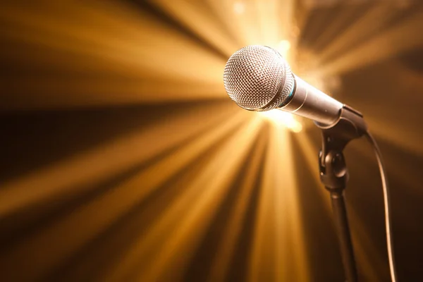 Microphone on stage with golden rays — Stock Photo, Image