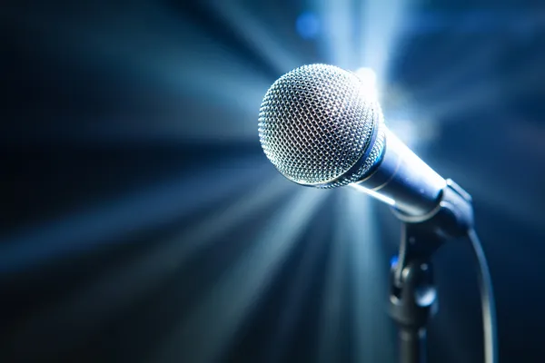 Микрофон на сцене с синим фоном — стоковое фото