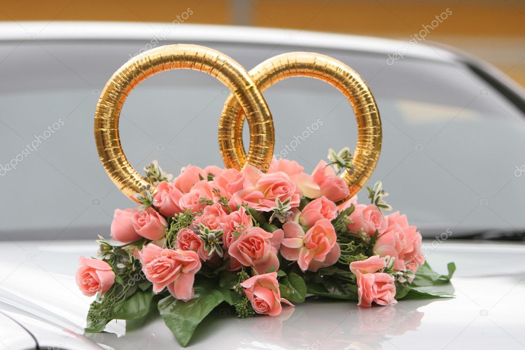 Wedding rings on the car with beautiful bunch of flowers