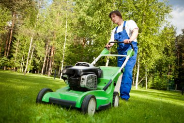 Lawn mover man working on the backyard clipart