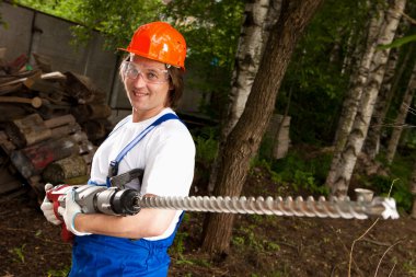 Smiling worker holding a machine drill clipart