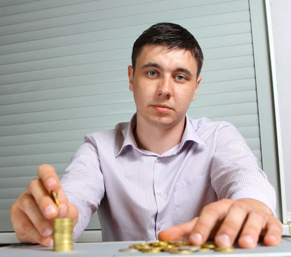 Biznesmen wprowadzenie monet w kolumnach — Zdjęcie stockowe