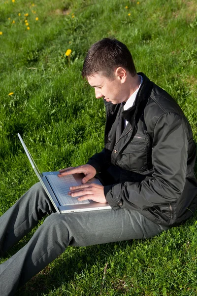 Çimlerin üstünde a laptop ile adam