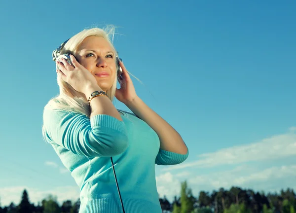 Young woman with headphones outdoors — Stock Photo, Image