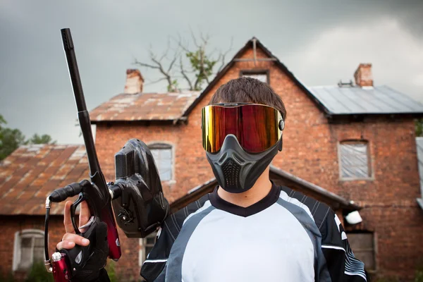 Paintball shooter and house as the background — Stock Photo, Image