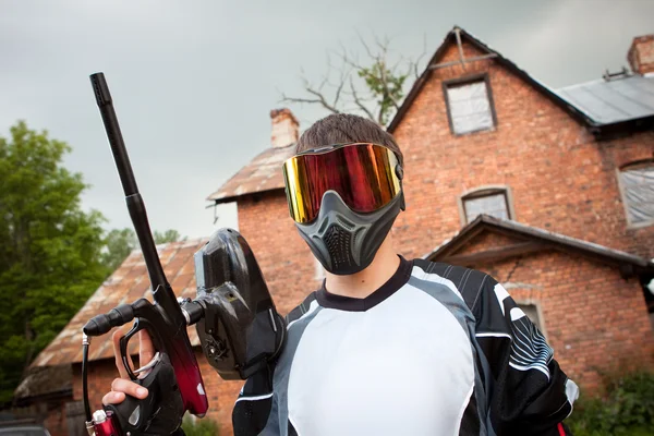 Paintball shooter dan rumah sebagai latar belakang — Stok Foto