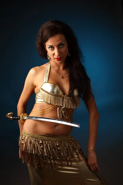 Dançarina do ventre segurando uma espada em seu lado — Fotografia de Stock