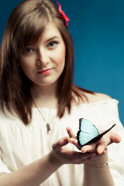 Молодая женщина, держащая бабочку — стоковое фото