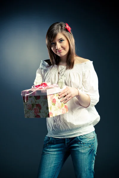 Vacker flicka håller en gåva — Stockfoto