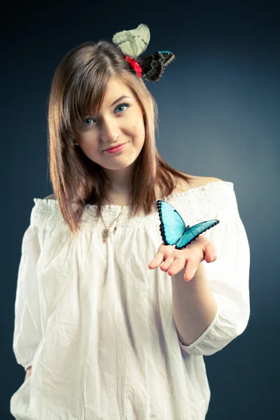 Beautiful girl holding a butterfly, focus on the butterfly — Stock Photo, Image