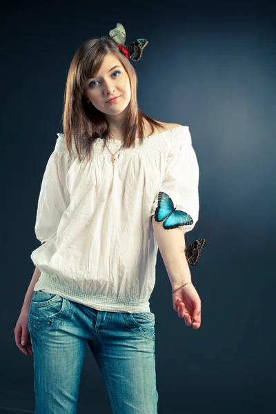 Красивая девушка и бабочка на ее руке — стоковое фото