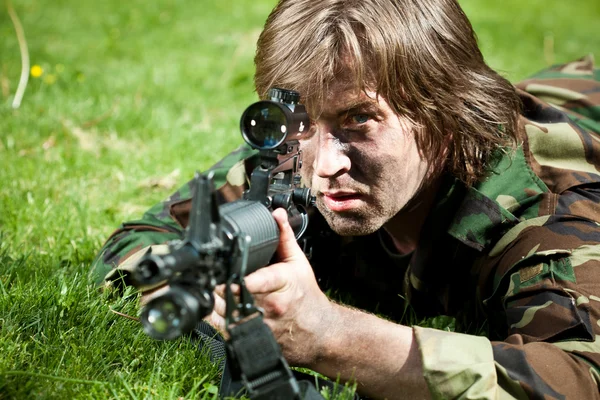 Soldado en el campo apuntando el arma — Foto de Stock