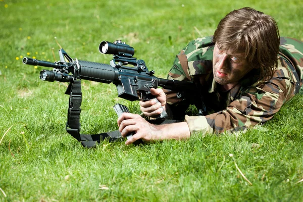 Солдат в поле, перезаряжая ружье — стоковое фото