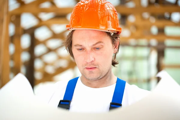 Builder tittar på konstruktionsplanen — Stockfoto