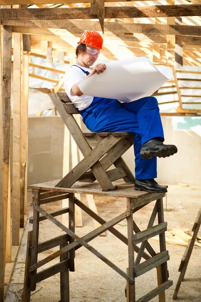 Construtor sentar-se no andaime de madeira — Fotografia de Stock