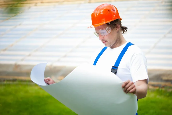 Builder looking at the construction plan — Stock Photo, Image