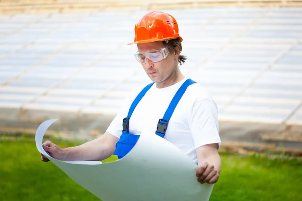 Engeneer olhando para o plano de construção — Fotografia de Stock