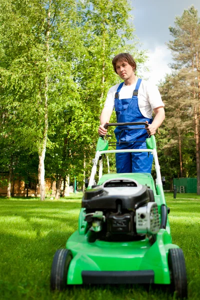 Homme de tondeuse de pelouse travaillant sur le jardin — Photo