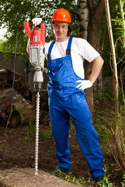 Trabajador sosteniendo un taladro de máquina — Foto de Stock