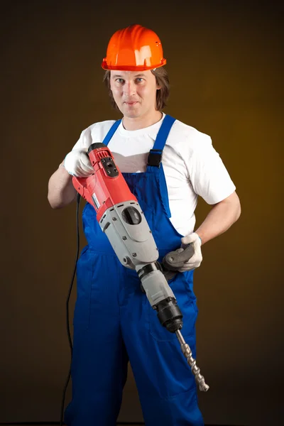 Trabajador sosteniendo un taladro de máquina — Foto de Stock