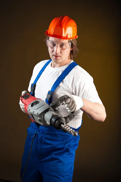 Arbeiter hält eine Bohrmaschine in der Hand — Stockfoto