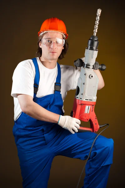 Arbeiter hält eine Bohrmaschine in der Hand — Stockfoto