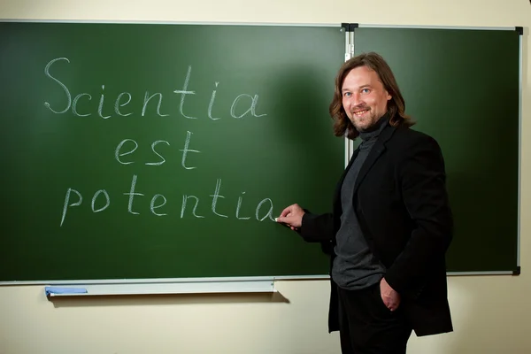 stock image Smiling professor writing on the blackboard