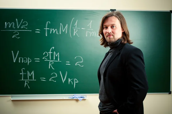 Учитель математики против доски — стоковое фото