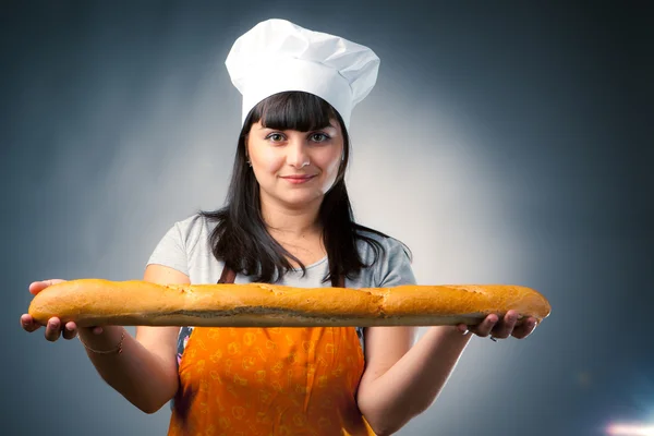 Woman cook offers a french bread — Stock Photo, Image